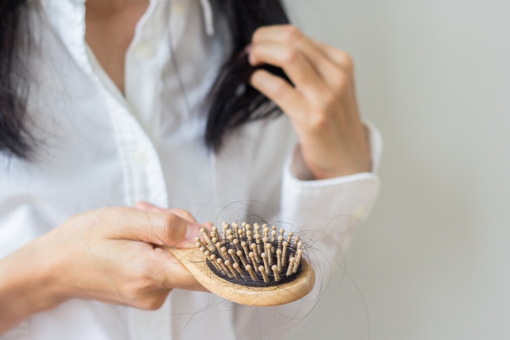 Women with hair loss from combing their hair. 